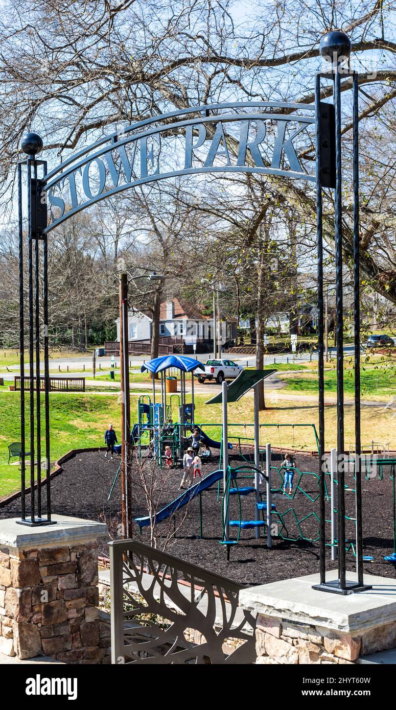 BELMONT, NC, USA-8 MARZO 2022: Stowe Park in centro. Mostra il parco giochi per bambini, con bambini e adulti in lontananza, e segno ad arco sopra l'entran Foto Stock