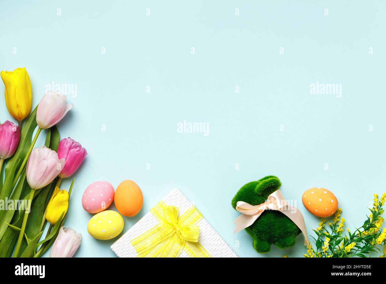 Biglietto di auguri di Pasqua. Tulipani fiori uova regalo coniglio su sfondo blu con spazio per testo e copia Foto Stock
