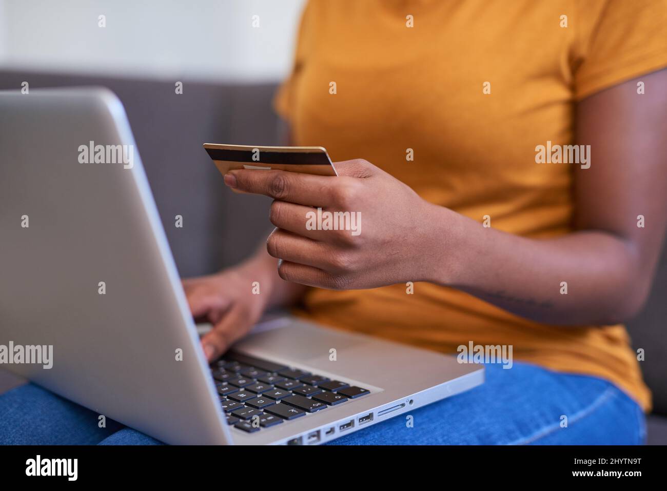 Un primo piano di una giovane donna in possesso di una carta di credito e shopping online Foto Stock