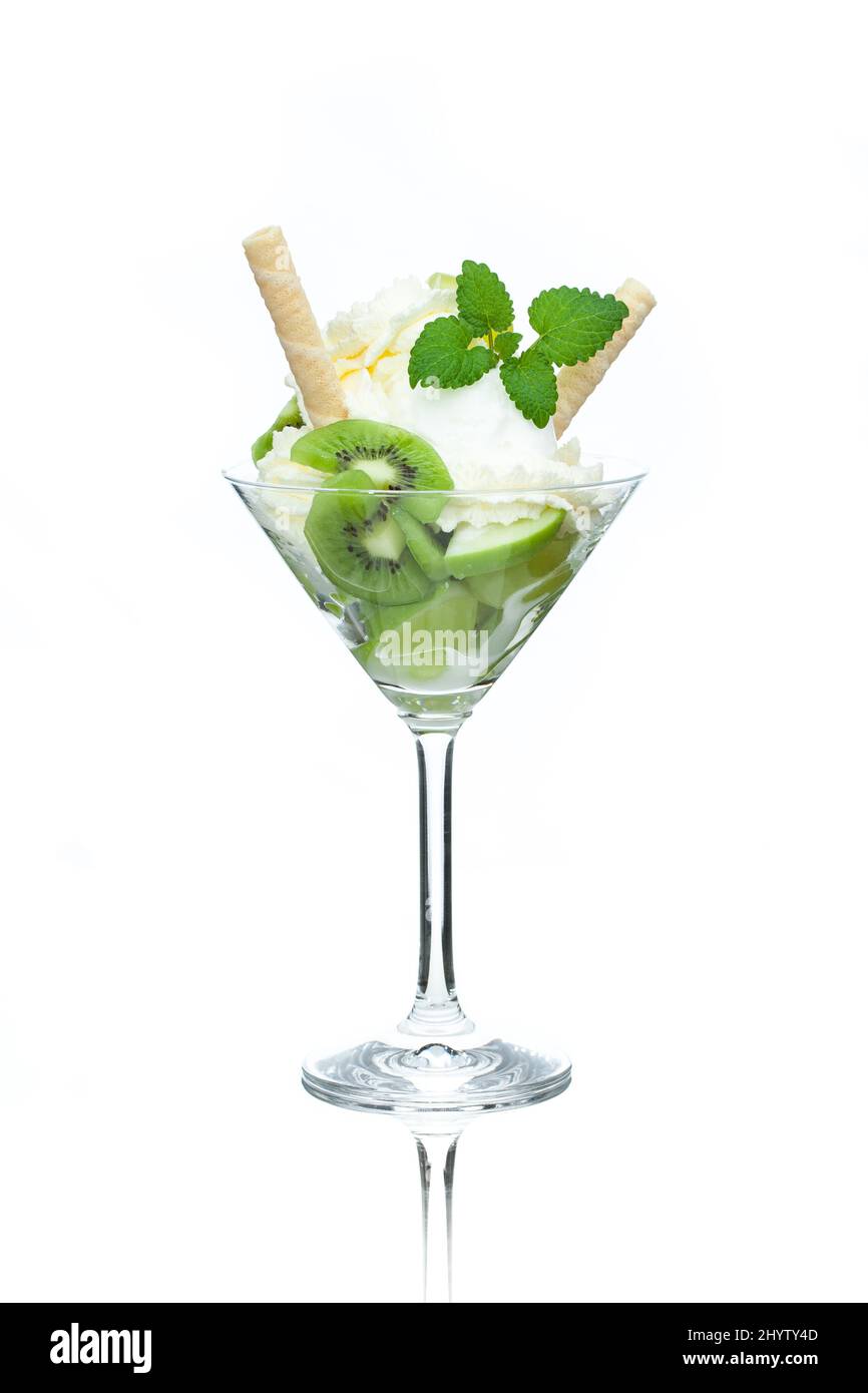 Una tazza di gelato al limone decorato con kiwi, coni e foglie di menta Foto Stock