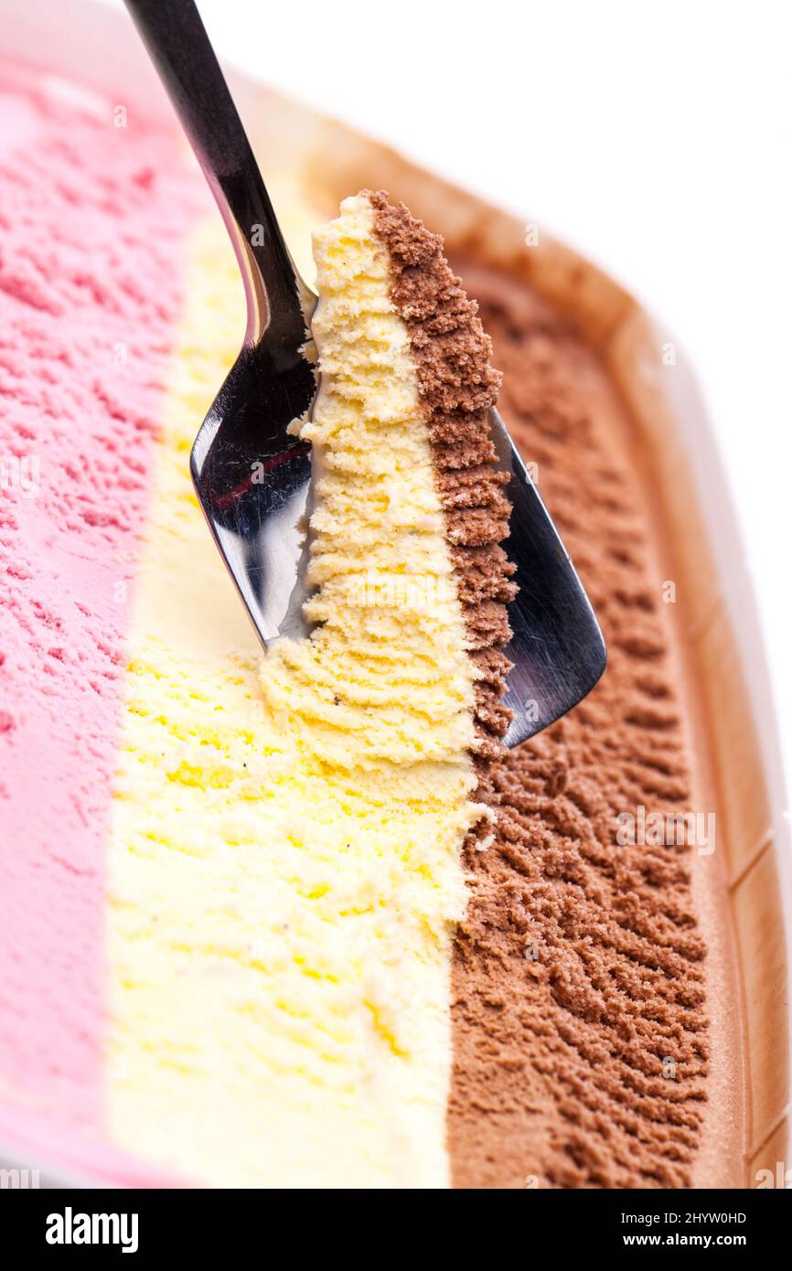 confezione famiglia di gelato aperta con 3 tipi di gelato di colore diverso e un cucchiaio Foto Stock