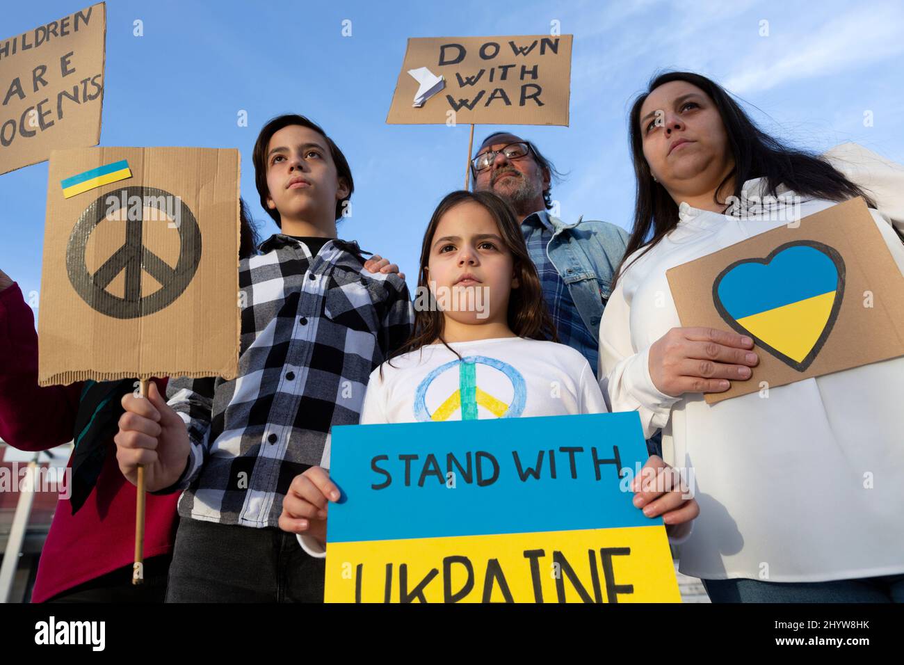 Un gruppo di manifestanti di pace protestano contro l'invasione russa. Mostrano poster e bandiere di Stop War con colori ucraini. Foto Stock