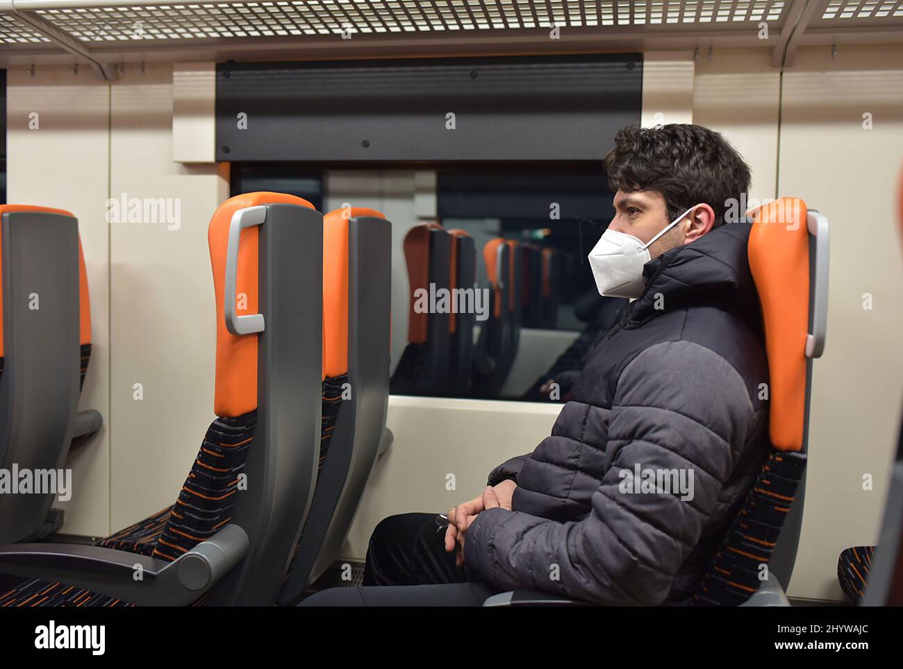 uomo con maschera seduta nel treno Foto Stock
