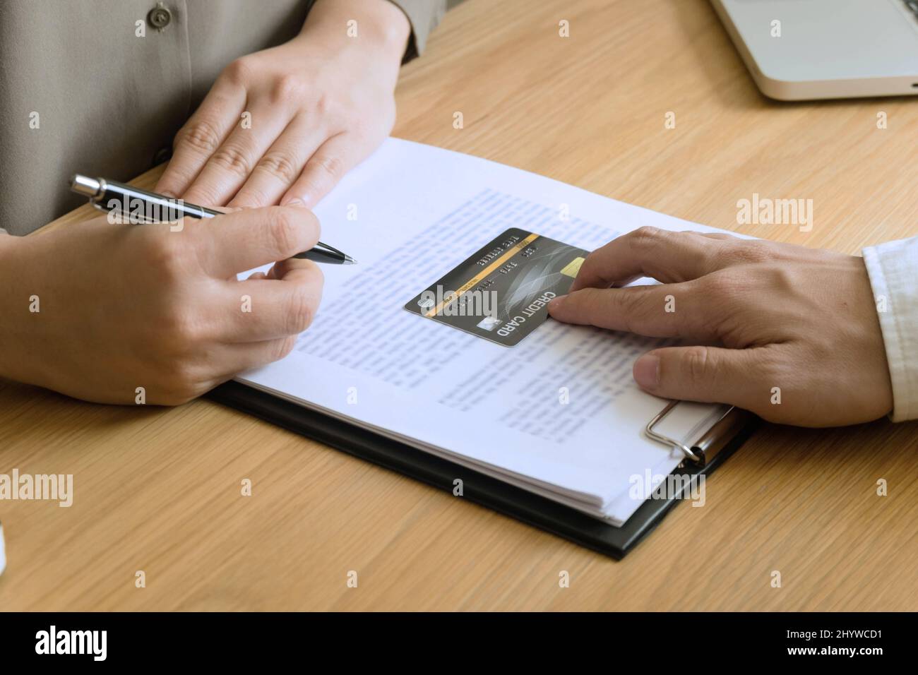 Donna che compila i documenti per richiedere una carta di credito sul tavolo. Foto Stock