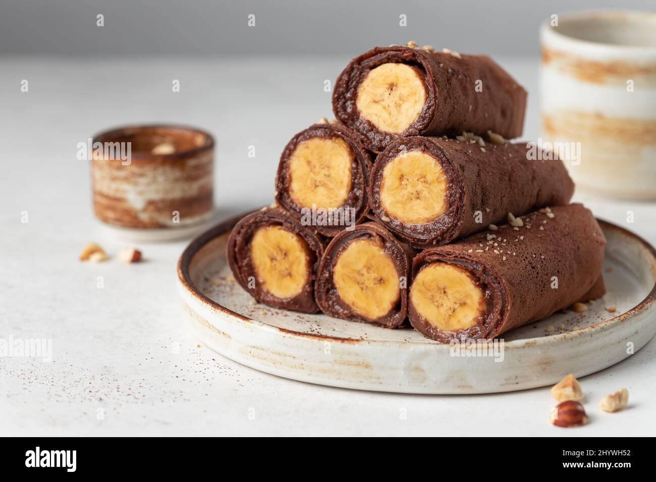 Crepes di cioccolato ripieno di banana su sfondo grigio Foto Stock