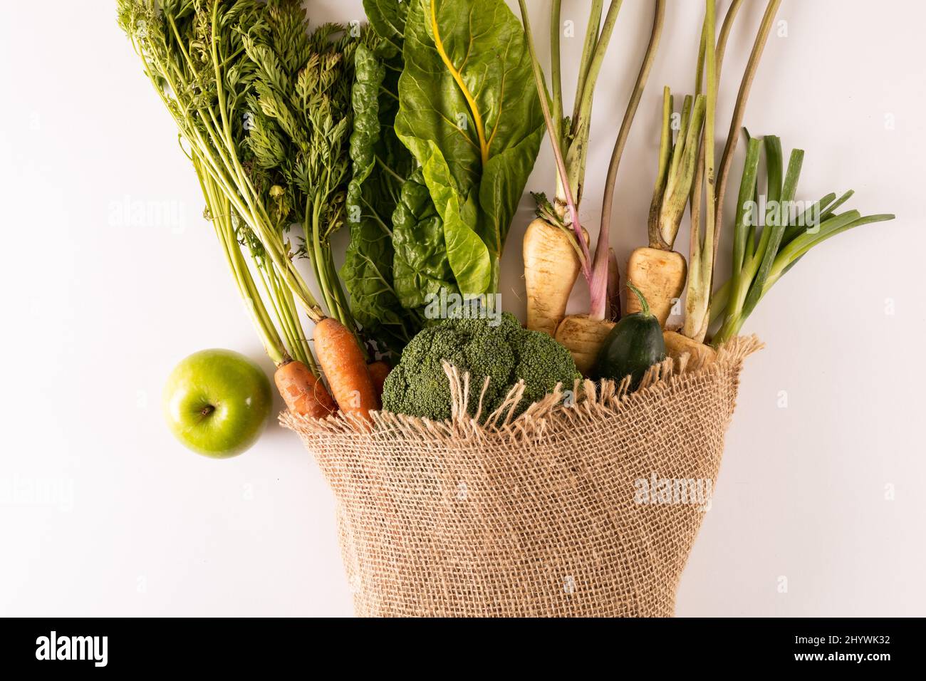 Vista dall'alto di verdure fresche con burlap su sfondo bianco, spazio copia Foto Stock
