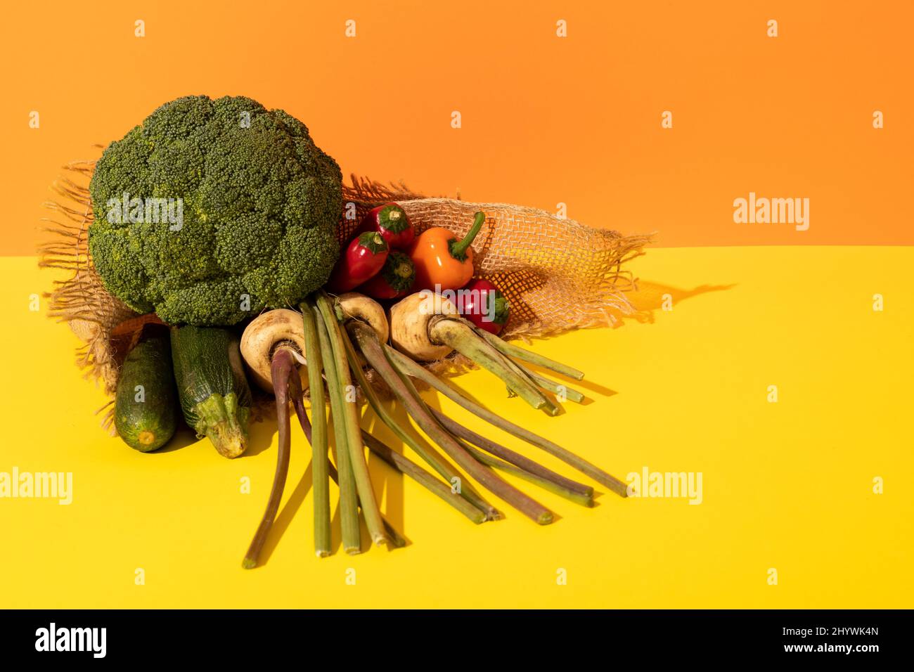 Vista ad angolo alto di varie verdure fresche organiche con burlap su sfondo a doppia tonalità, spazio copia Foto Stock