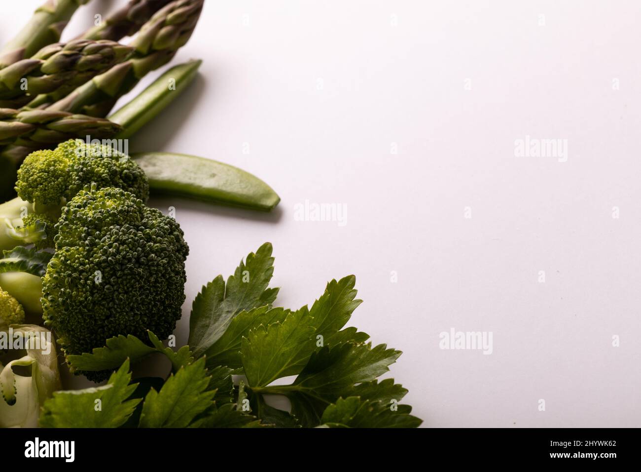 Primo piano di varie verdure verdi su sfondo bianco, spazio di copia Foto Stock