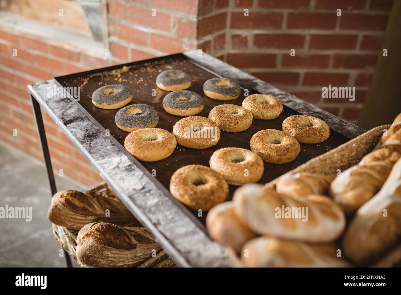Vista ad angolo alto di ciambelle e pane disposti sul tavolo in panetteria Foto Stock