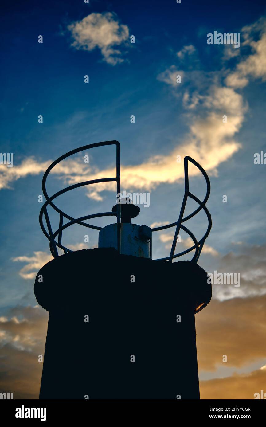primo piano di faro e nuvole al tramonto in una zona costiera. Cantabria, Spagna, Europa. Foto Stock