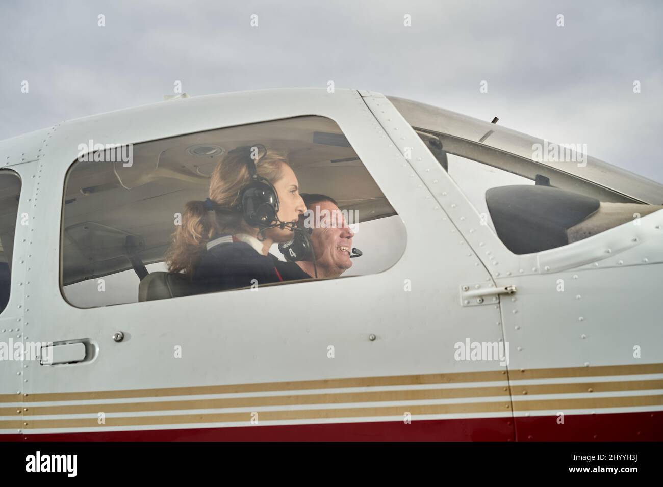 Aereo in volo. Istruttore di volo femminile che dà lezioni di volo ad uno studente. Foto Stock