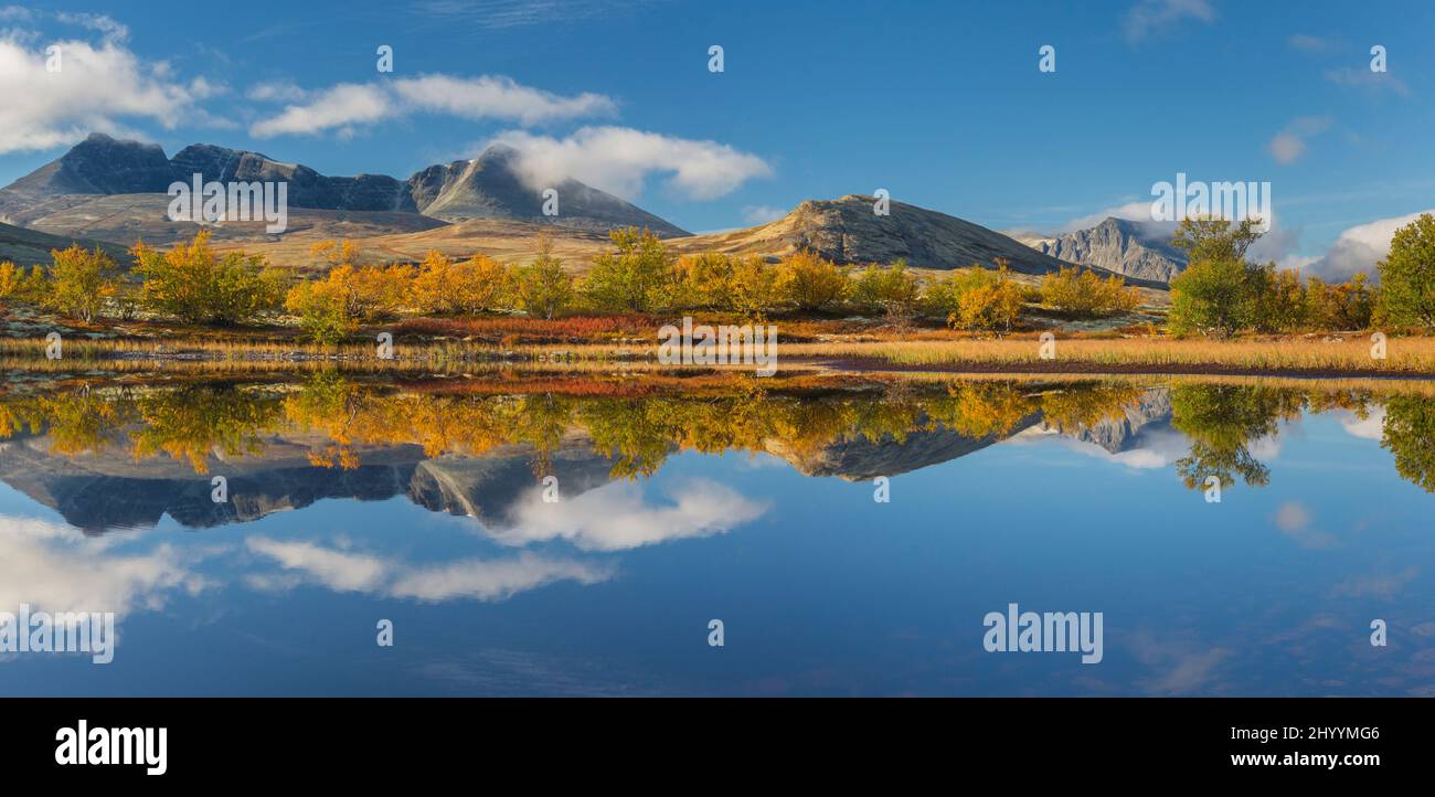 Le montagne Høgronden e Digerroneamente si riflettevano in acqua di lago in autunno, Døråldalen nel Parco Nazionale di Rondane, contea Innlandet, Oppland, Norvegia Foto Stock