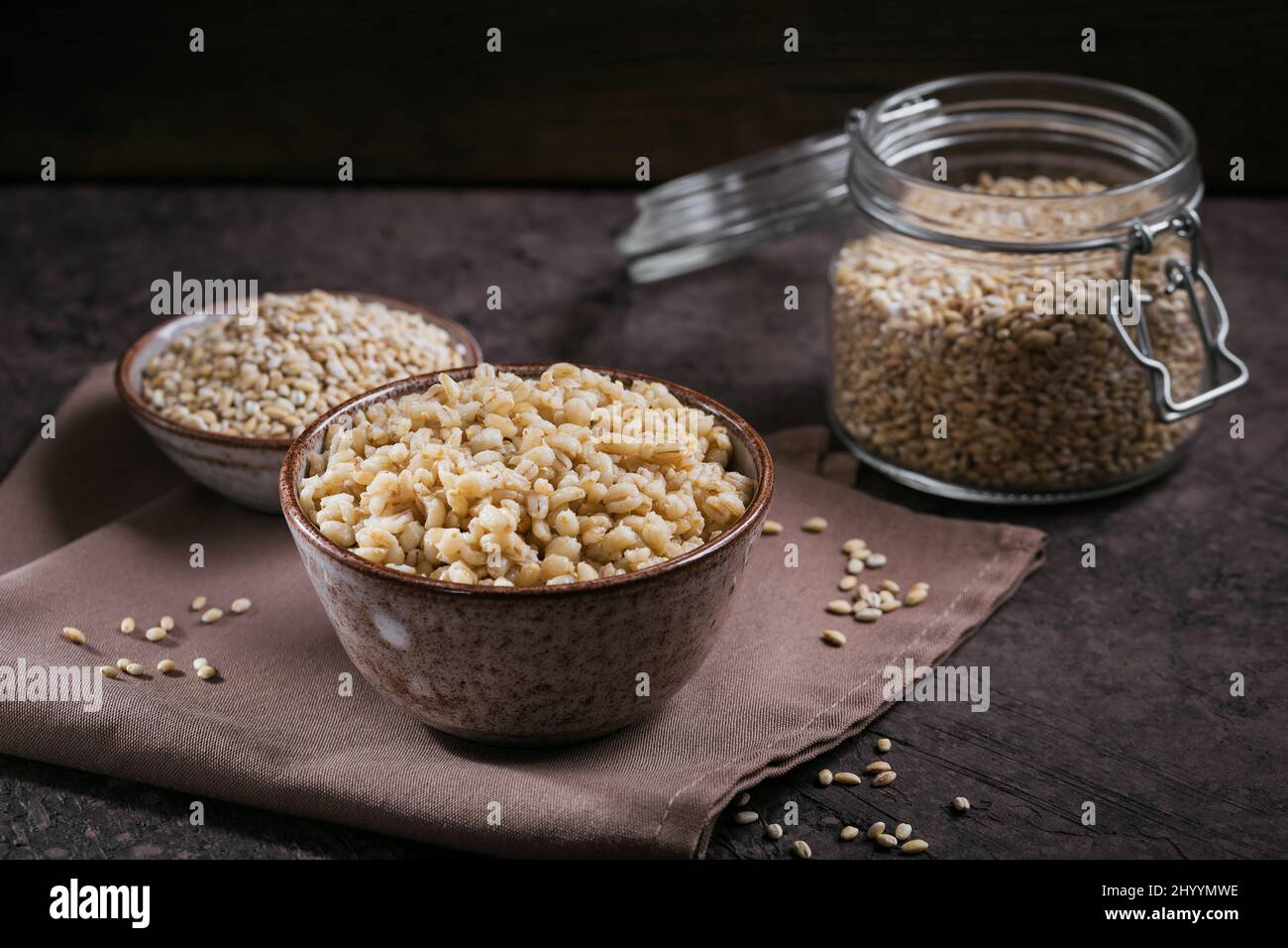 Gustoso porridge di cereali di orzo perlato in una ciotola su sfondo scuro. Concetto di cibo sano e dietetico. Foto Stock