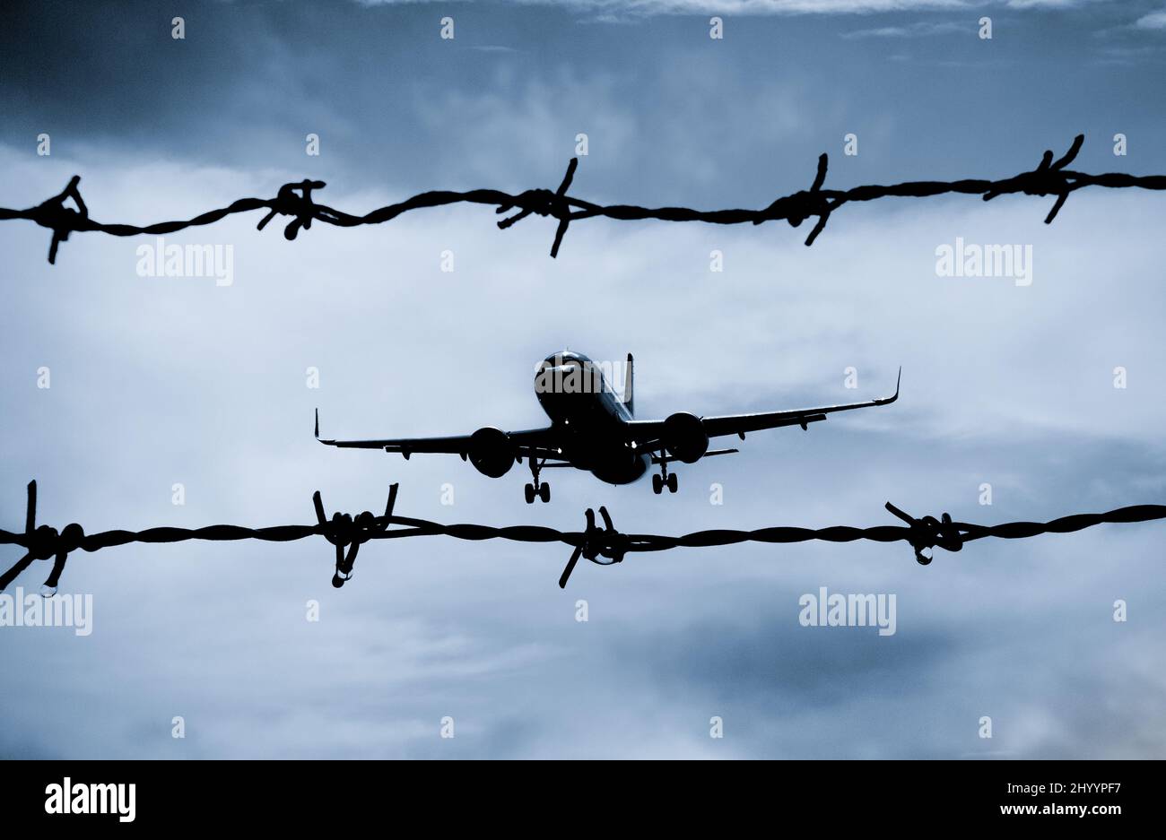 Aeroplano, aereo visto attraverso la recinzione di bordo del filo spinato. Immagine del concetto: Zona di volo NO, conflitto Ucraina Russia, recinzione di frontiera, attraversamento Foto Stock