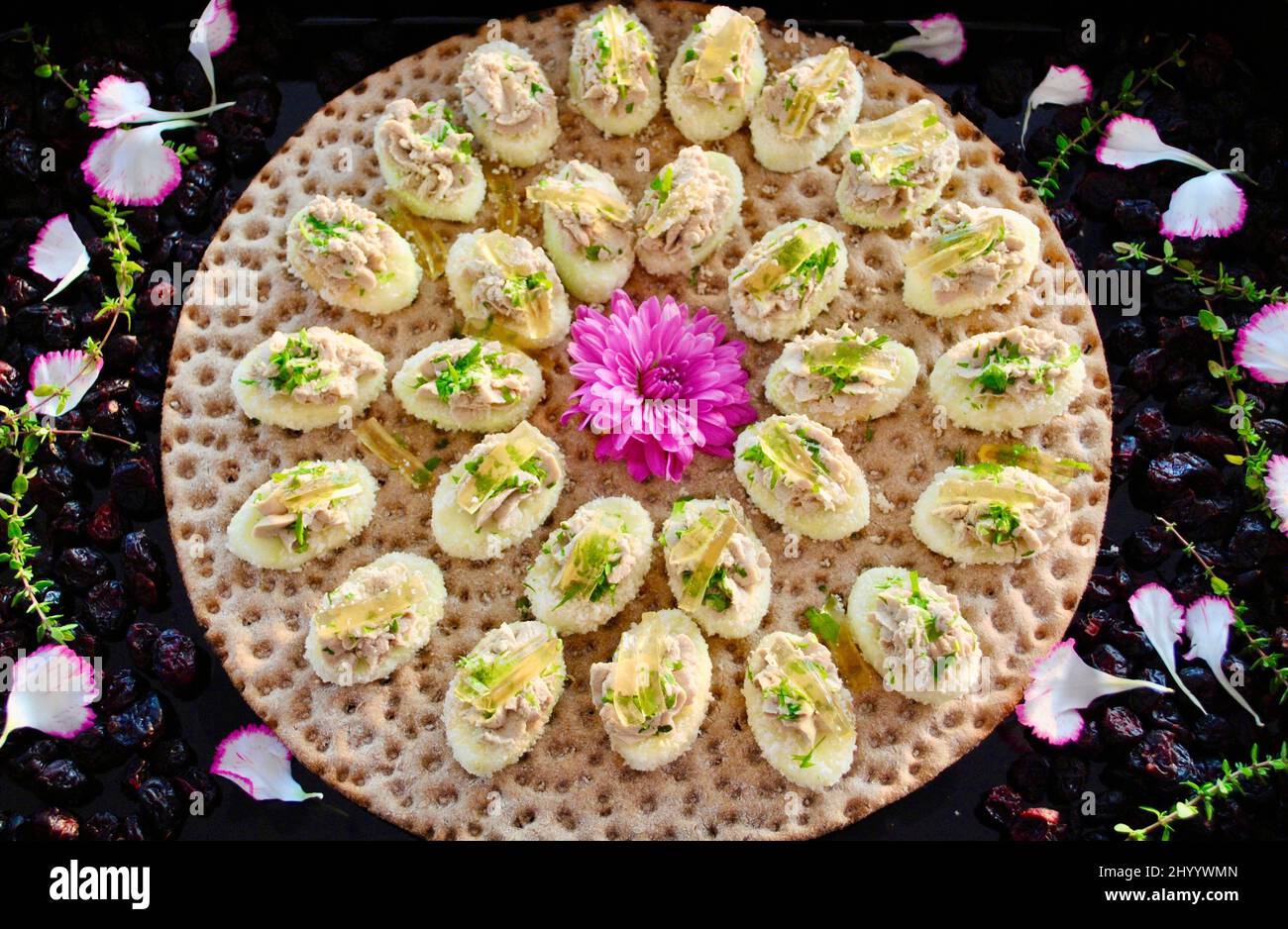 Mousse al tartufo sulla mela intorno al fiore di mauve sul croccante svedese decorato con mirtilli secchi e petali di fiori Foto Stock