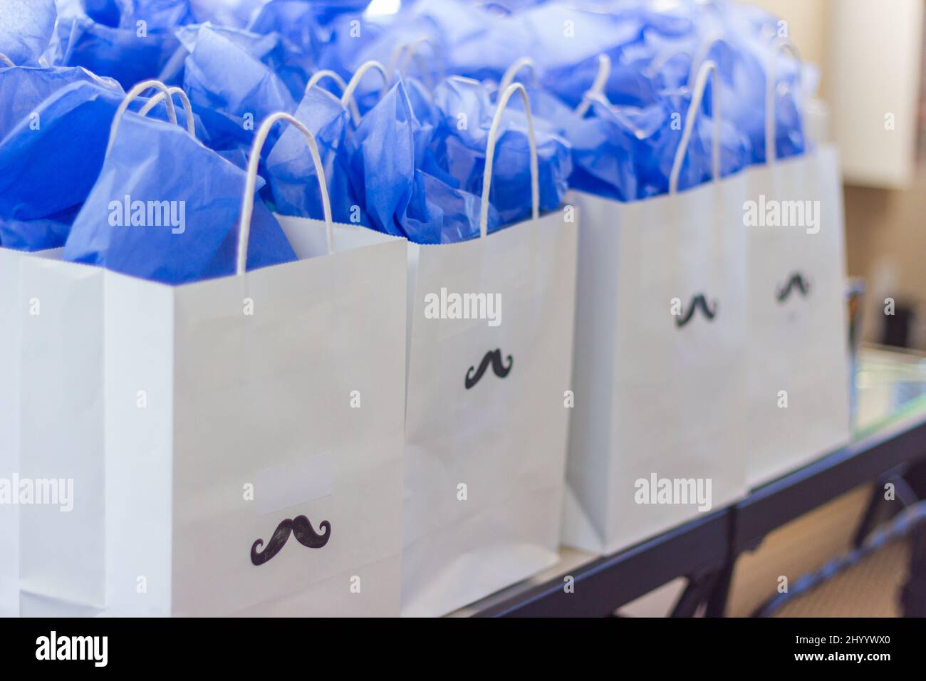 Borse regalo con carta blu da imballaggio e maniglie poste su un bancone al primo compleanno di un bambino Foto Stock