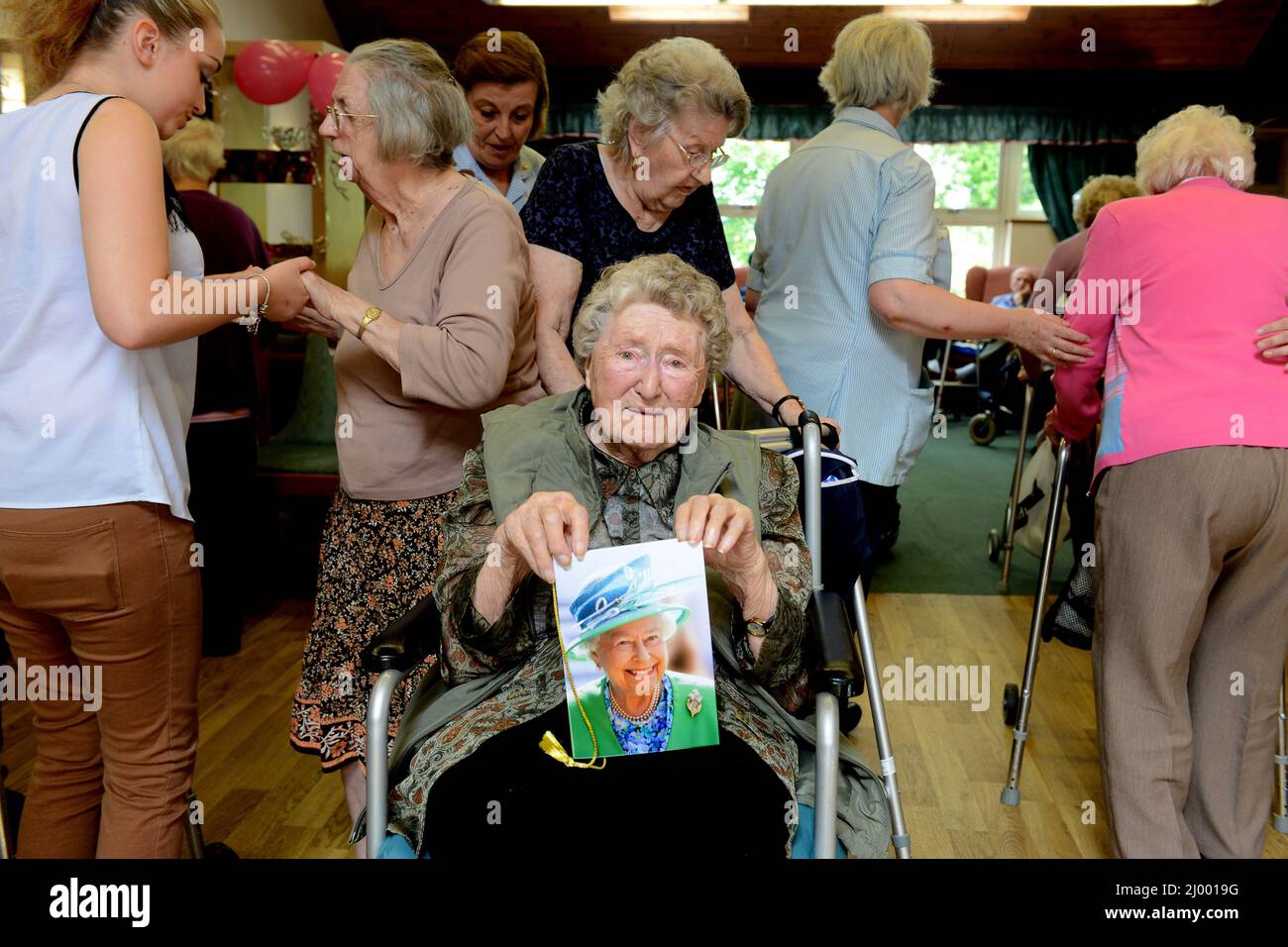 Care Home residente celebrare il suo 100th compleanno tenendo la sua carta dalla Regina. Foto Stock