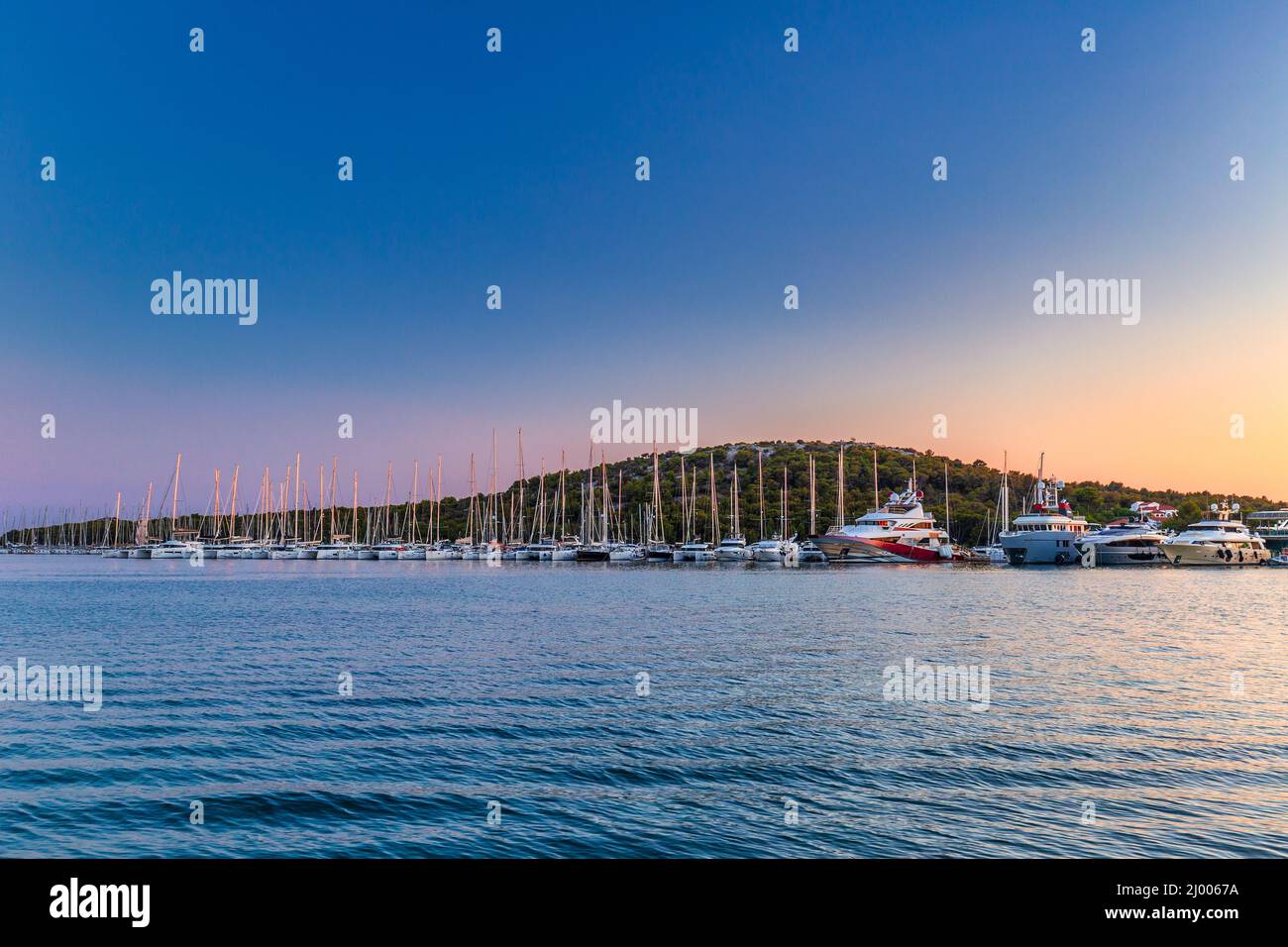 Tramonto sulla baia del mare nel villaggio di Rogoznica, una popolare destinazione turistica sulla costa dalmata del mare Adriatico in Croazia, Europa. Foto Stock