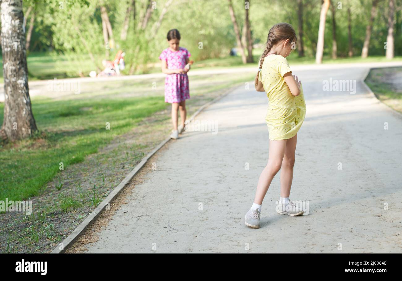 Due bambine sono in piedi nel parco sul percorso. Il concetto di disputa tra sorelle, risentimento. Foto di alta qualità Foto Stock