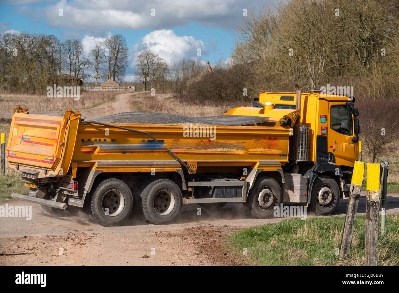 Wiltshire calcestruzzo giallo brillante Renault C430 camion 8x4 con cassone ribaltabile Abba in movimento su una corsia di campagna Foto Stock