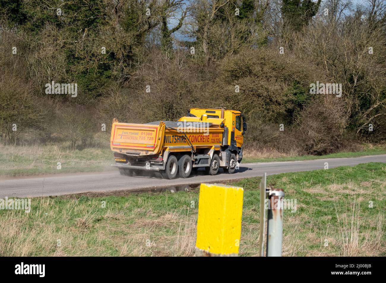 Wiltshire calcestruzzo giallo brillante Renault C430 camion 8x4 con cassone ribaltabile Abba in movimento su una corsia di campagna Foto Stock