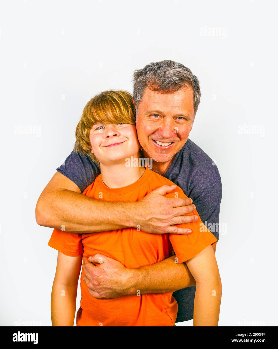 Padre e figlio abbracciando in studio isolato su bianco Foto Stock