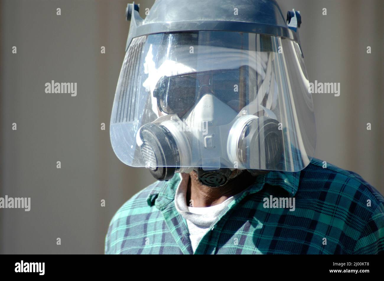 Uomo che indossa la maschera di icurezza e lo sfiatatoio lavorando sulla ricostruzione commrcial passerella con la fresa Foto Stock