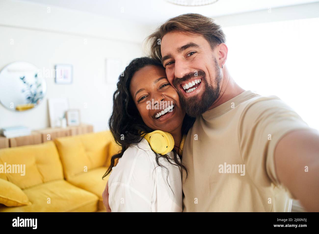 Persone felici che si godono a casa. Ragazza e ragazzo scattano una foto sorridente guardando la fotocamera. Coppia innamorata Foto Stock