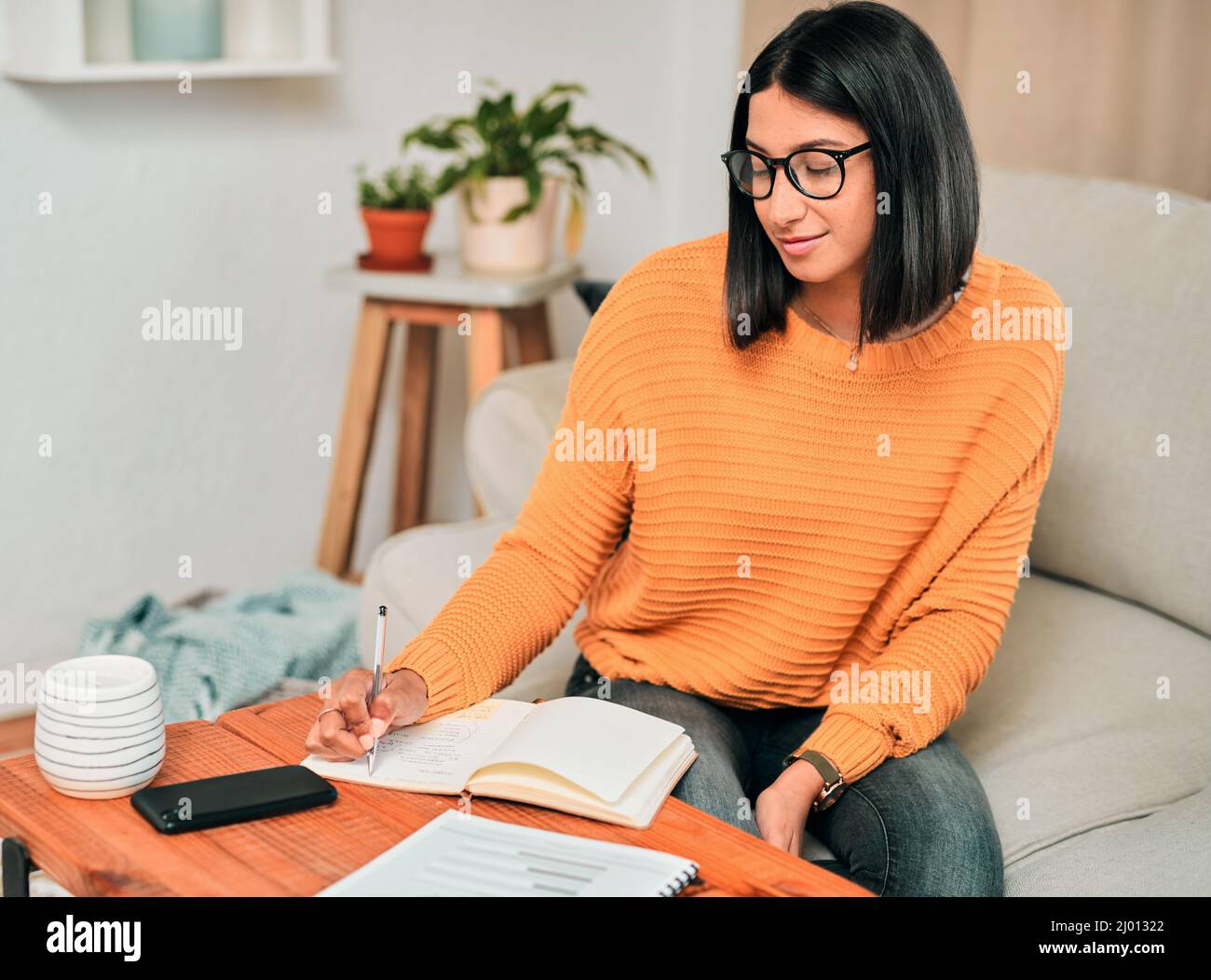 Il successo accade a coloro che gestiscono il loro tempo. Scatto di un giovane che lavora sul divano a casa. Foto Stock