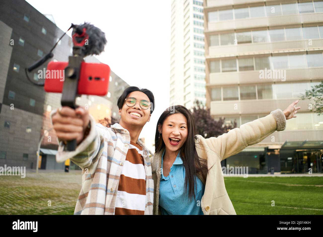 Persone asiatiche blogging all'aperto. Coppia selfie felice viaggio a piedi turisti scattare foto con telefono sulla città strada panorama lifestyle. Foto Stock