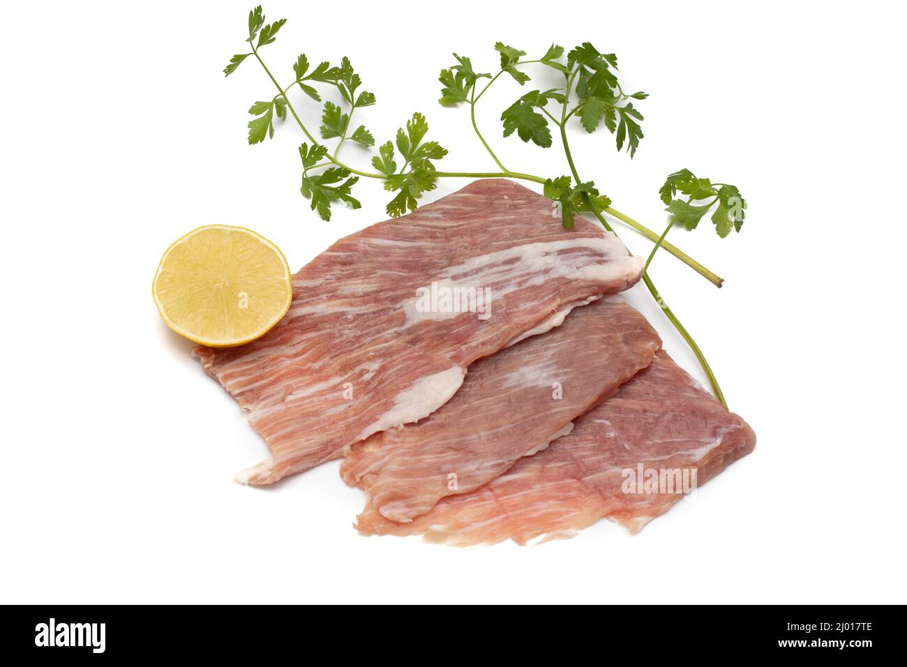 Un segreto iberico, è una carne di maiale molto apprezzata in Spagna. Crudo, guarnito con prezzemolo e mezzo limone. Isolato su sfondo bianco. Foto Stock