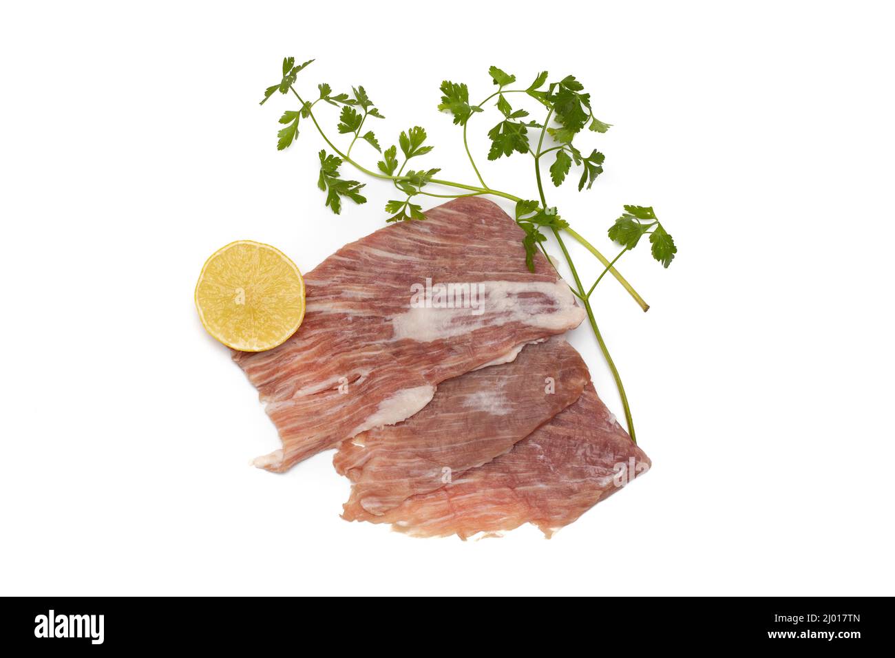 Un segreto iberico, è una carne di maiale molto apprezzata in Spagna. Crudo, guarnito con prezzemolo e mezzo limone. Isolato su sfondo bianco. Foto Stock