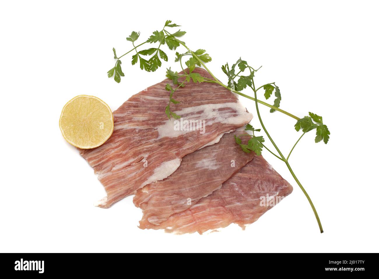 Un segreto iberico, è una carne di maiale molto apprezzata in Spagna. Crudo, guarnito con prezzemolo e mezzo limone. Isolato su sfondo bianco. Foto Stock