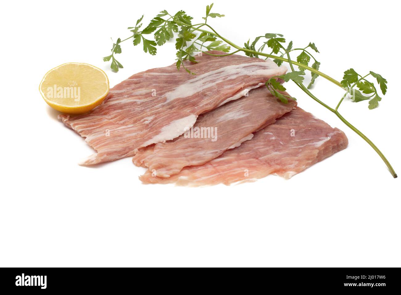 Un segreto iberico, è una carne di maiale molto apprezzata in Spagna. Crudo, guarnito con prezzemolo e mezzo limone. Isolato su sfondo bianco. Foto Stock