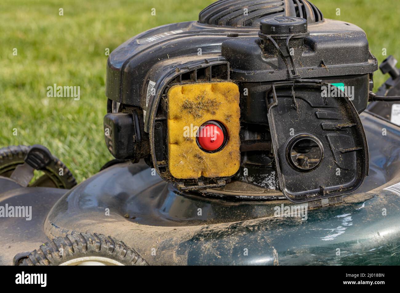 Filtro dell'aria sporco sul rasaerba. Concetto di riparazione, manutenzione e messa a punto del motore di piccole dimensioni Foto Stock