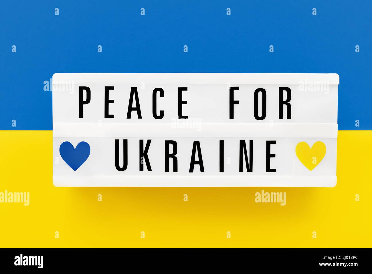 PACE PER L'UCRAINA scritto in una scatola luminosa su sfondo di colori della bandiera Ucraina. Vista dall'alto Foto Stock