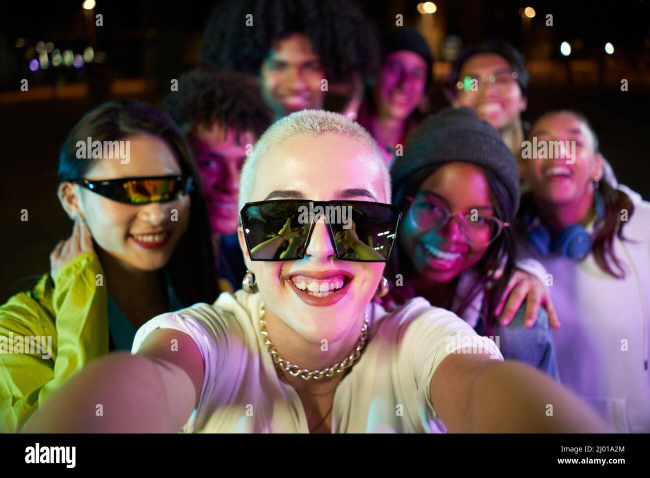 Gruppo multirazziale di persone che prendono un selfie in una discoteca party. Amici felici divertirsi insieme in un night club. Foto Stock