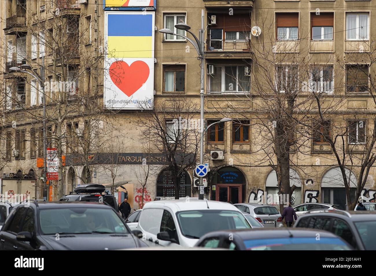 Bucarest, Romania - 15 marzo 2022: Bandiera Ucraina è sul muro di un edificio nel centro di Bucarest in solidarietà con il popolo ucraino duro h Foto Stock