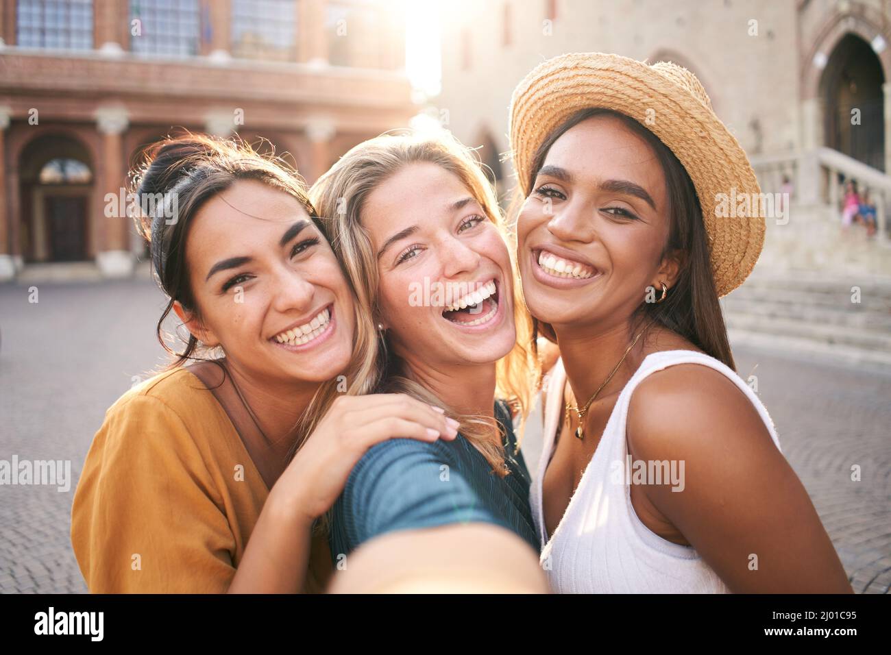 Tre giovani donne di hipster sorridenti in abiti estivi. Ragazze che scattano foto autoritratto selfie su smartphone.Models posing in the Street.Female mostrando Foto Stock