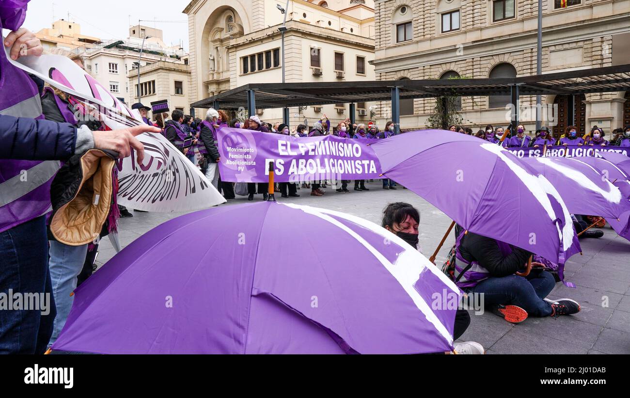 Manifestazione femminista per l'abolizione della prostituzione con ombrelloni e striscioni viola in Spagna Foto Stock