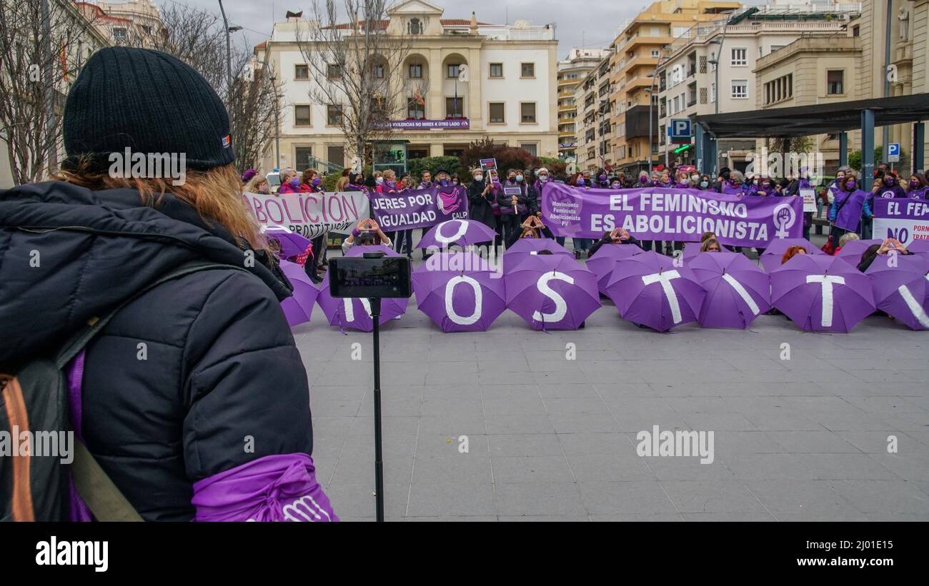 Manifestazione femminista per l'abolizione della prostituzione con ombrelloni e striscioni viola in Spagna Foto Stock