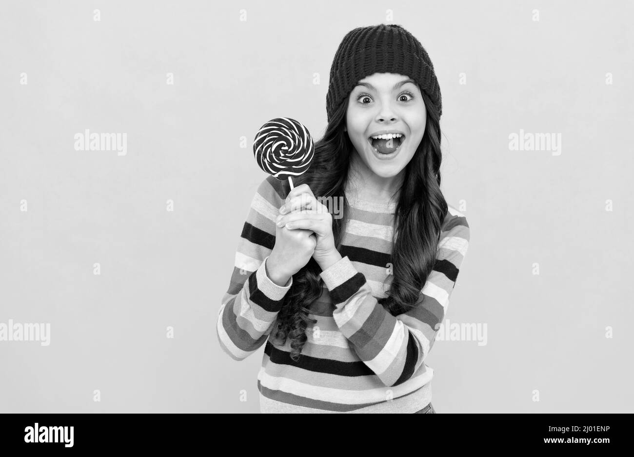 sorpresa ragazza capretto tenere lollipop dolce, copia spazio, negozio di caramello Foto Stock