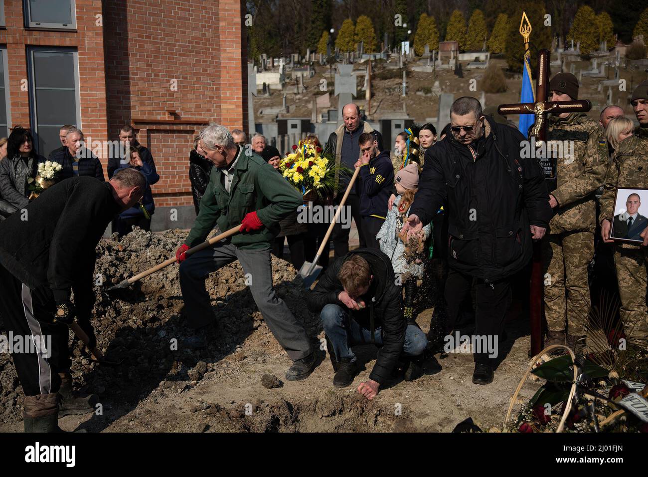 Lviv, Ucraina. 15th Mar 2022. I lutto pagano gli ultimi rispetti a quattro soldati caduti a Lviv, Ucraina. Tre soldati ucraini uccisi nell'13th attacco missilistico da parte della Russia a Yavoriv militare campo di addestramento sono stati posti a riposo. Credit: SOPA Images Limited/Alamy Live News Foto Stock