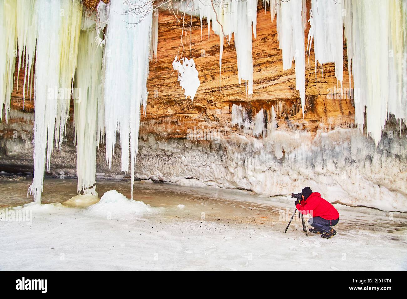 Fotografo che cattura l'immagine delle ghiacciate sulle scogliere rocciose Foto Stock