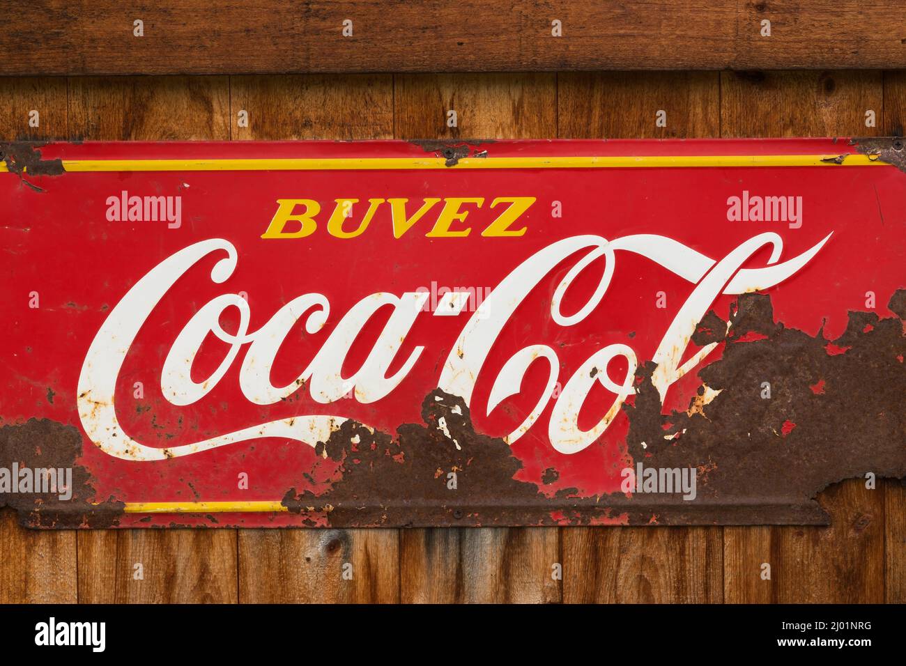 Vintage Coca Cola soft drink azienda rettangolare metallo pubblicità segno per i consumatori di lingua francese esposto su rustico legno tavola parete. Foto Stock