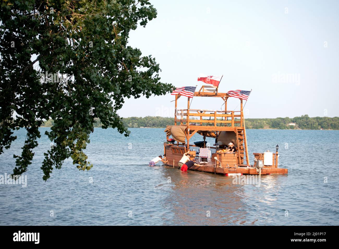 Grande barca a tre livelli che vola le bandiere americane e polacche godendo di viaggio sul lago. Clitherall Minnesota, Stati Uniti Foto Stock
