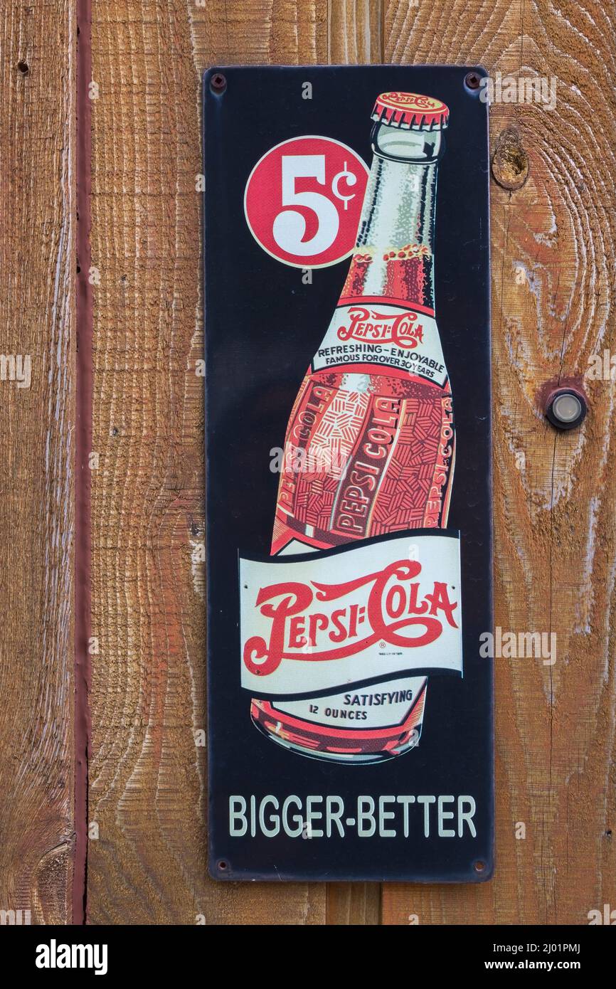 Vecchia Pepsi Cola soft drink società più grande meglio 5 cents bottiglia metallo pubblicità segno pubblicato su rustico legno tavola parete. Foto Stock