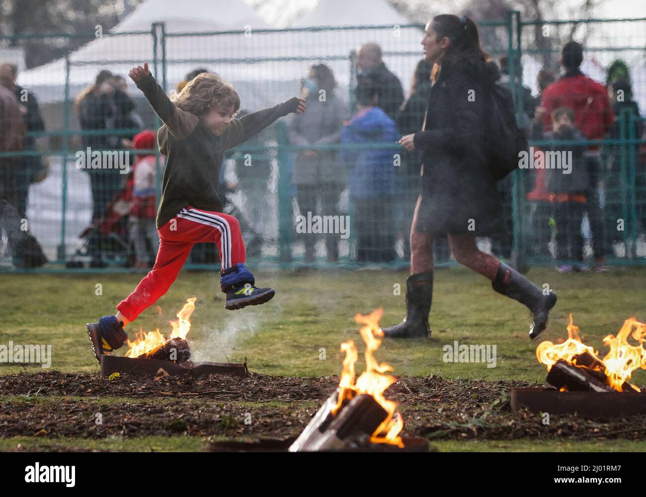 Vancouver, Canada. 15th Mar 2022. Un bambino salta sopra un falò durante il Festival del fuoco ad Ambleside Park a Vancouver occidentale, Columbia Britannica, Canada, 15 marzo 2022. Il Festival del fuoco è celebrato dagli iraniani alla vigilia dell'ultimo mercoledì prima di Nowruz, il nuovo anno iraniano. Credit: Liang Sen/Xinhua/Alamy Live News Foto Stock