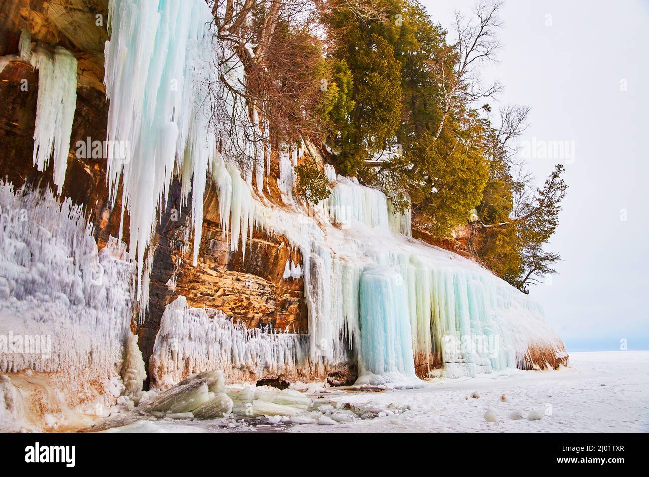 Scogliere mozzafiato in inverno coperte di ghiaccioli e ghiacciate cascate di blu Foto Stock