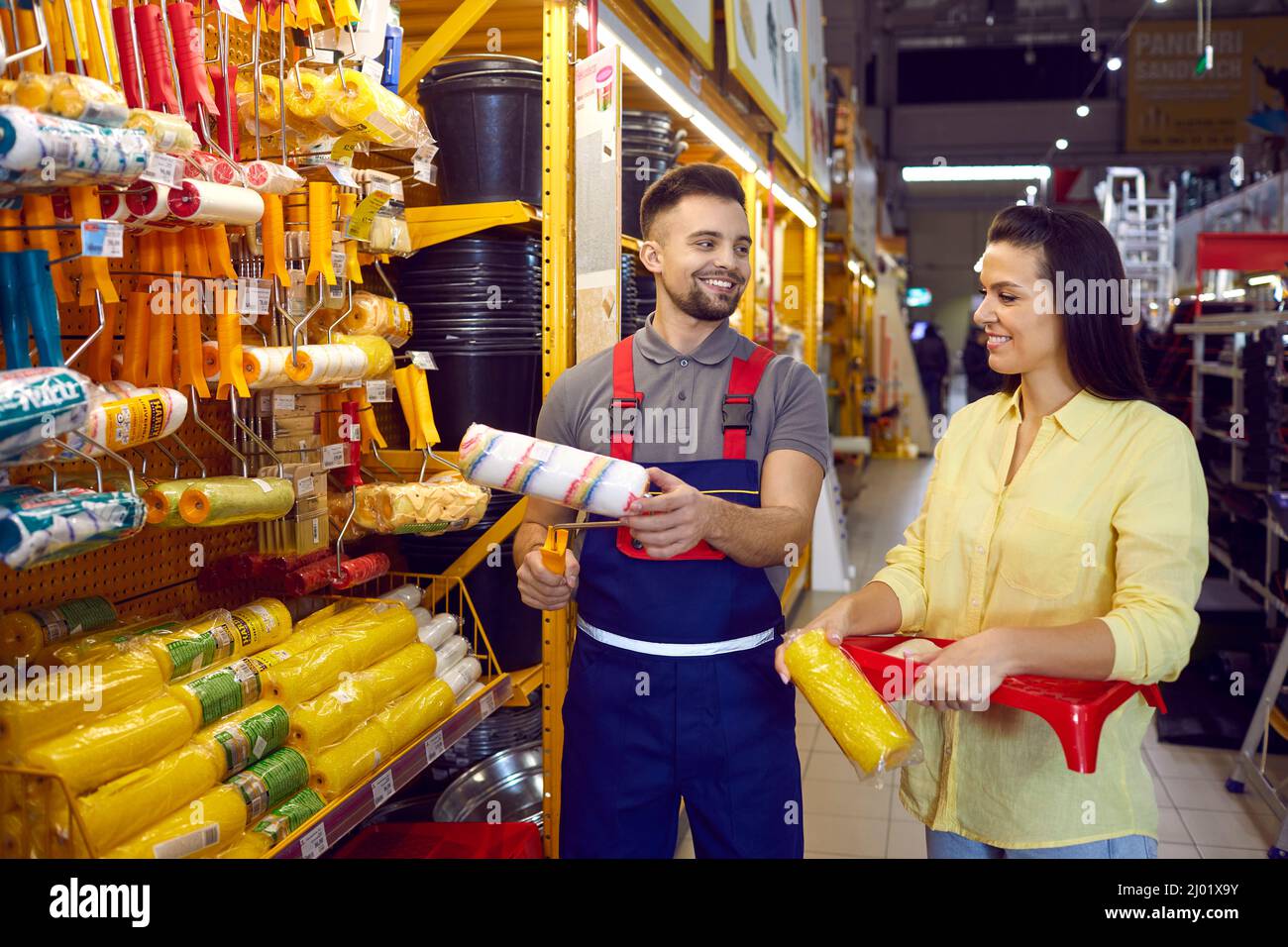 Un venditore sorridente consulta il cliente femminile nel negozio dell'edificio Foto Stock
